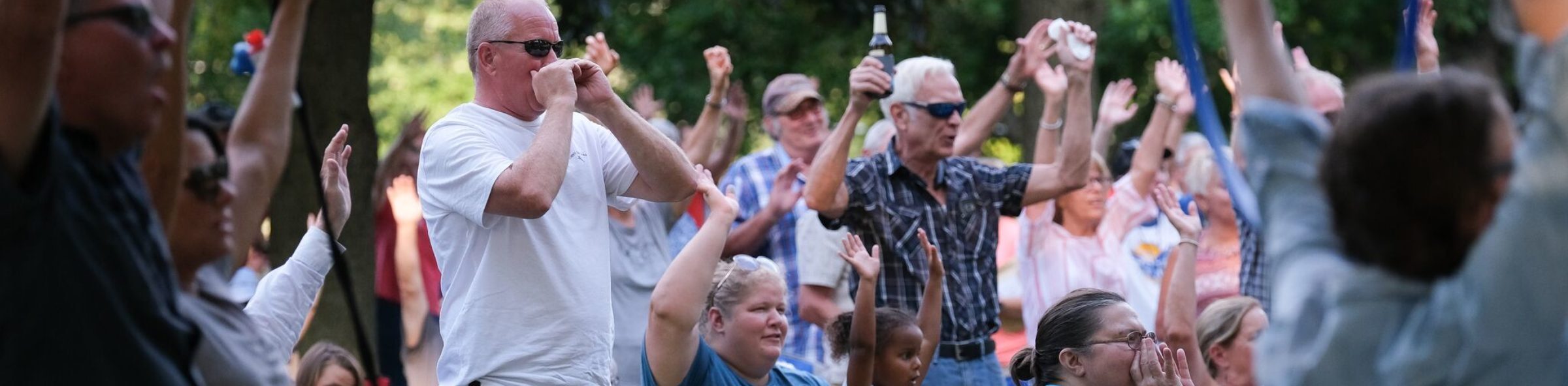 Concertgoers cheering together at a Galva Music outdoor concert